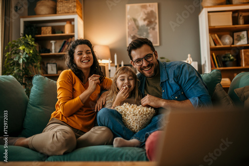 The joy of togetherness as a mom, dad, and daughter share a movie and popcorn in their living room
