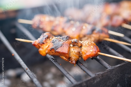glazed chicken wings on skewers over charcoal