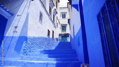 an alley way with some bright blue steps in front of a building © Wirestock