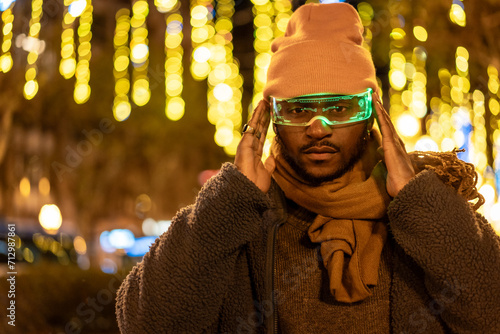 African man in warm clothes using smart glasses at night