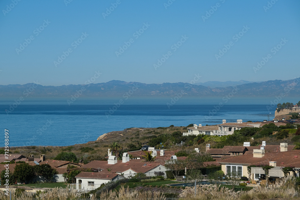 Breathtaking scenic and landscape view of coastline of Rancho Palos Verdes with vegetation and cliffs and beautiful bays overlooking ocean and coast in California on sunny blue sky day