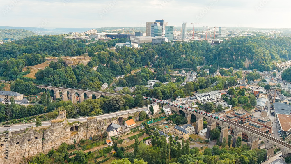 Luxembourg City, Luxembourg. Railway with train. Bridge system. The city is located in a deep valley of two rivers - Alzette and Petrus, Aerial View