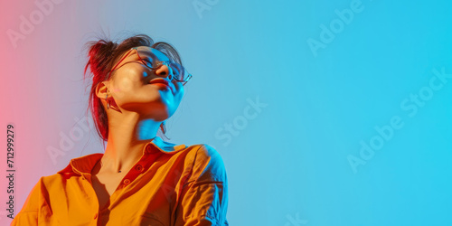 Banner with a confident modern happy young Asian woman on studio blue background and copy space photo