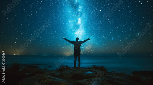 A man has his hands up, a beautiful view of the night sky