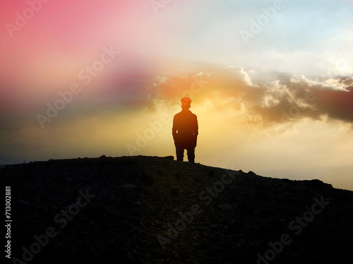 silhouette of a person standing on the top of mountain