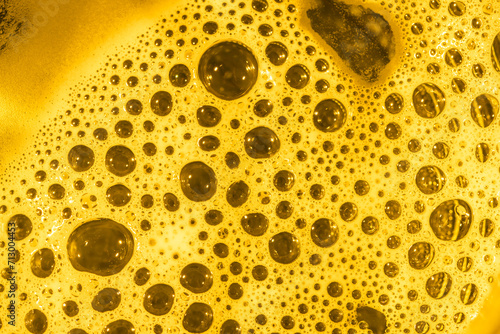 Żółte intensywne, żywe tło - okrągłe bąbelki w jaskrawej pianie photo