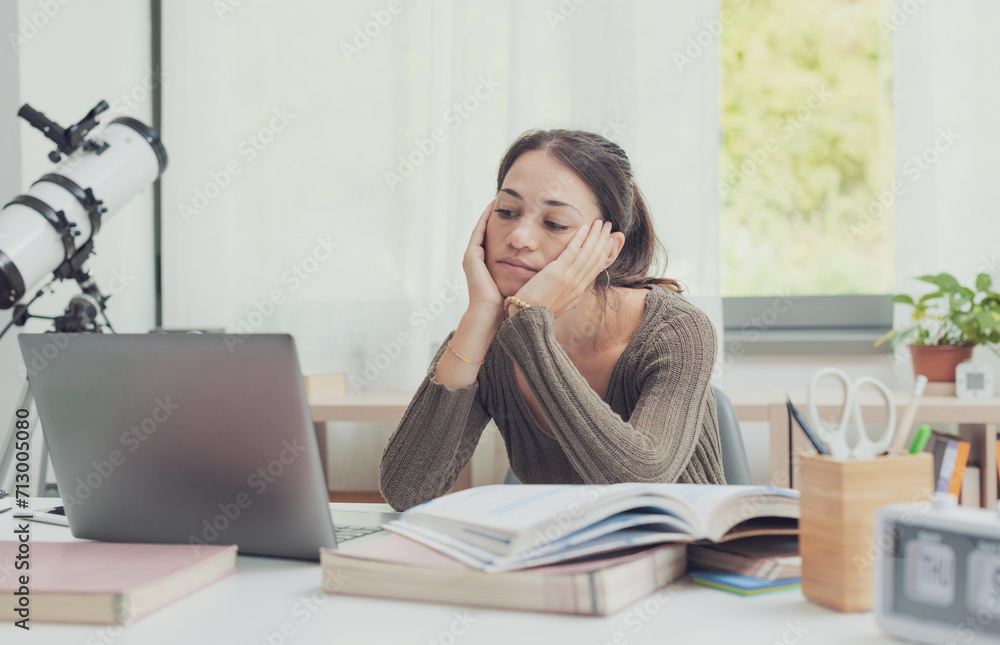 Bored tired student looking at laptop screen Bored tired student looking at laptop screen