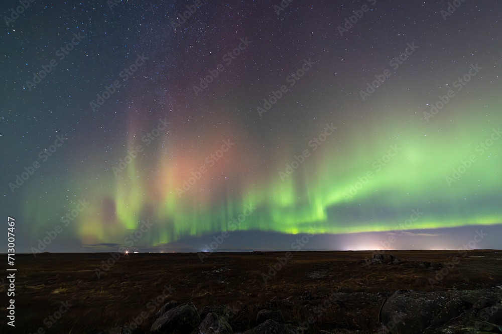 Northern Lights over Keflavik area in Iceland with green and purple colors