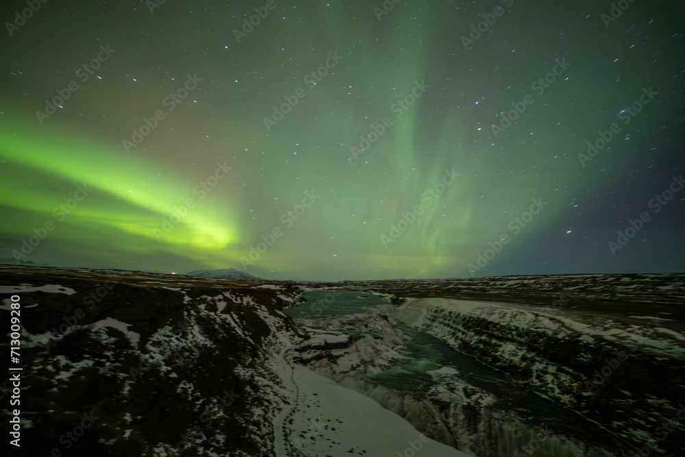 Northern lights in Gullfoss area in winter with ice in Iceland