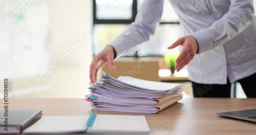 Female manager puts stack of office documents on table photo