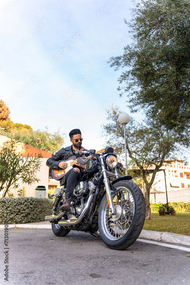 Fototapeta premium Hipster guitarist playing electric guitar on his motorcycle. Grunge style.