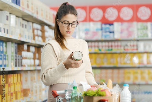 Fotografia Woman checking a food label at the grocery store