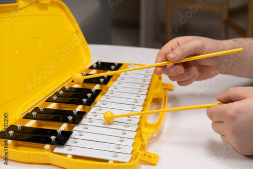 Playing with sticks on a metallophone, a metal xylophone. Percussion Musical Instrument photo