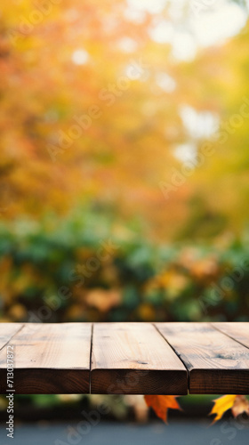 Empty blank wooden table fall background with autumn trees orange yellow color leaves backdrop forest or park nature scene abstract blurred bokeh tabletop for product display desk mockup. Copy space.
