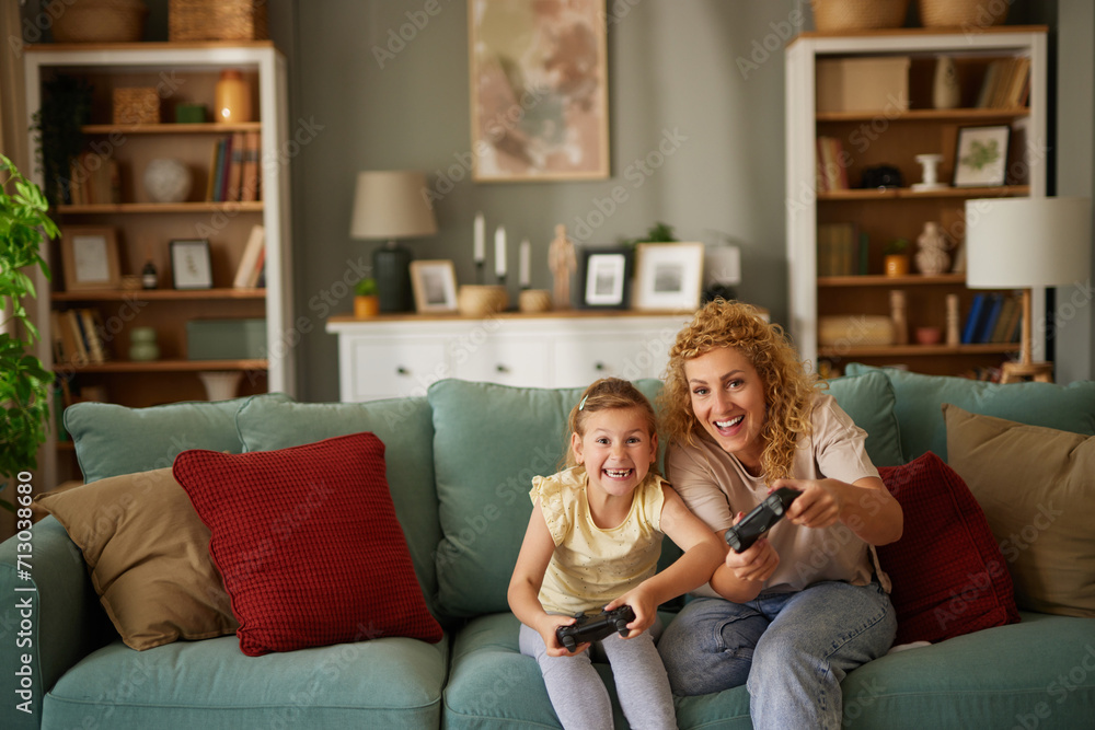 Obraz premium Mother and daughter playing video games at home