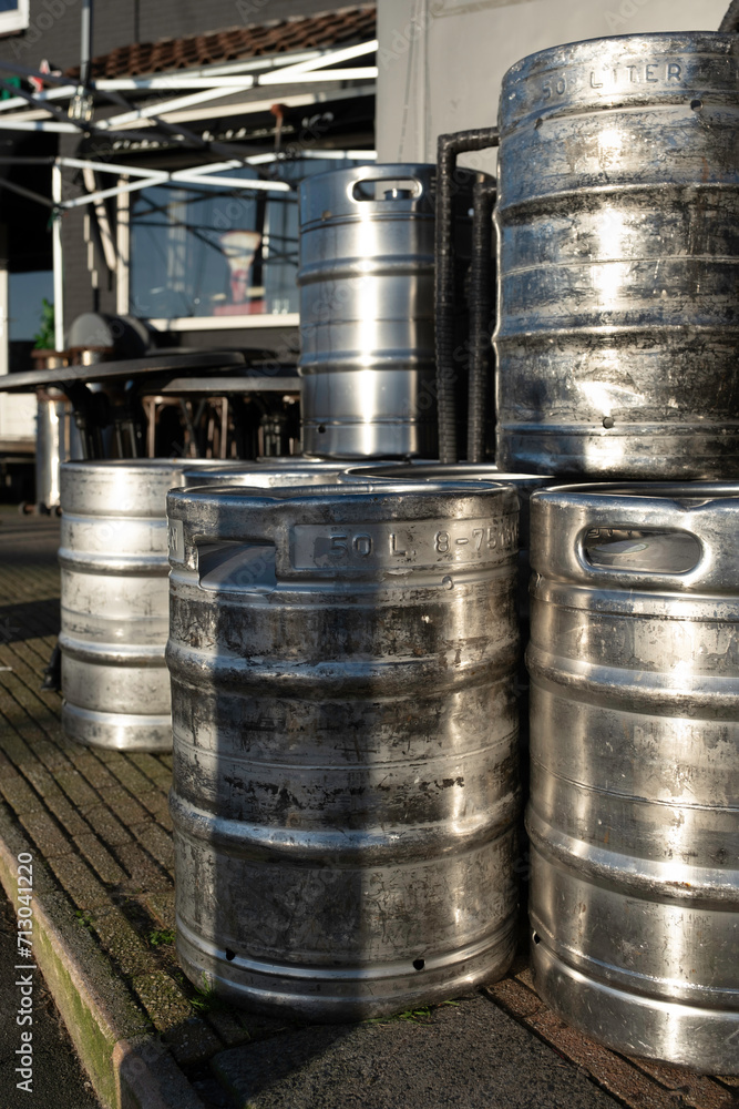 Stacked large 50 liter metal beer barrels on the terrace of a café Stacked large 50 liter metal beer barrels on the terrace of a café