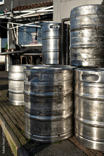 Stacked large 50 liter metal beer barrels on the terrace of a café