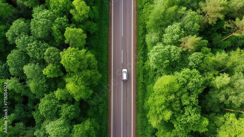 Aerial top view of highway road in the middle of green forest photo