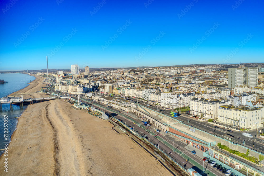 Aerial photo of Brighton Beach and Madeira Drive towards the Victorian Palace Pier, a popular seaside resort in East Sussex England.