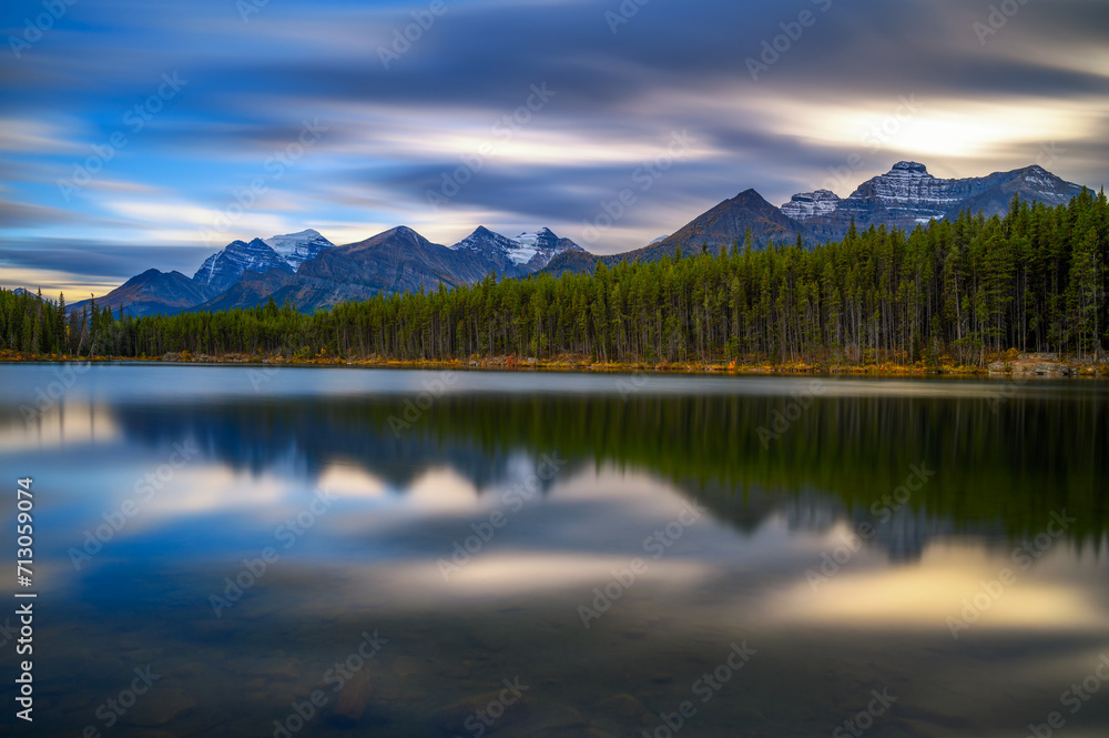 Scenic sunset over Herbert Lake along the roadside of the Icefields Parkway in Banff National Park, Alberta, Canada, with mountain reflections. Long exposure.