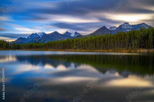Scenic sunset over Herbert Lake along the roadside of the Icefields Parkway in Banff National Park, Alberta, Canada, with mountain reflections. Long exposure.