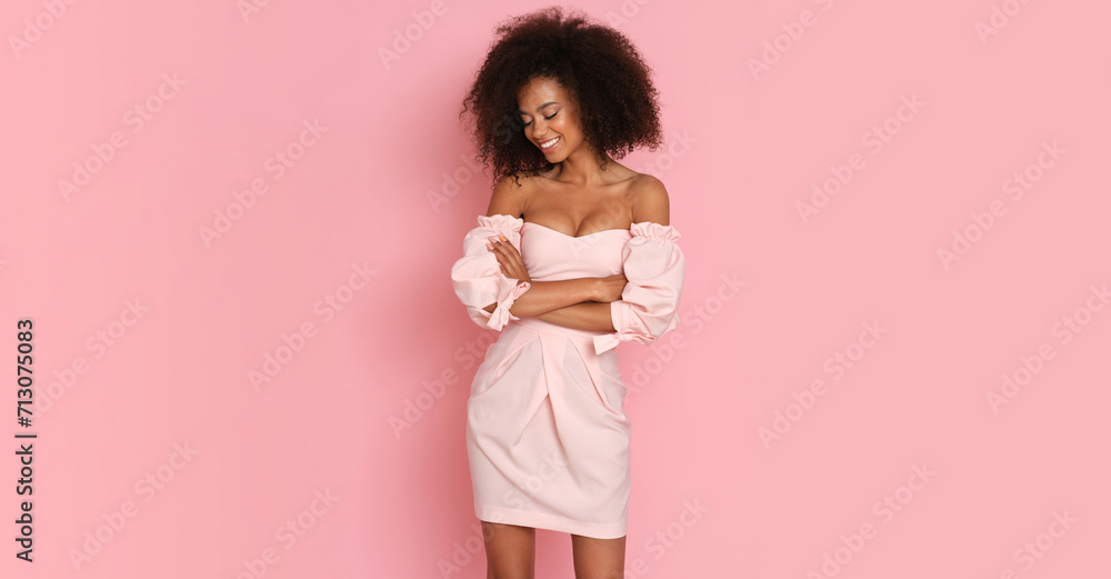 Obraz na płótnie Beautiful afro american woman in a pink dress on a pink background. w salonie