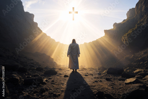 Jesus Christ standing at entrance to tomb. resurrection of Christ. light from heaven. Jesus is risen out of a dark stone cave into light. Easter photo