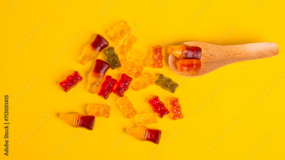jelly bears candy and spoon wooden isolated on a yellow background. Jelly Bean. jelly bears candy and spoon wooden isolated on a yellow background. Jelly Bean.