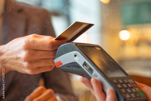 Woman customer paying with contactless credit card in a restaurant.  photo