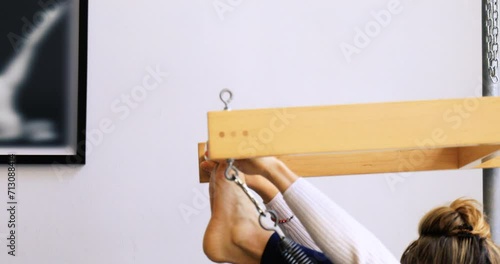 young woman practicing pilates on a reformer machine