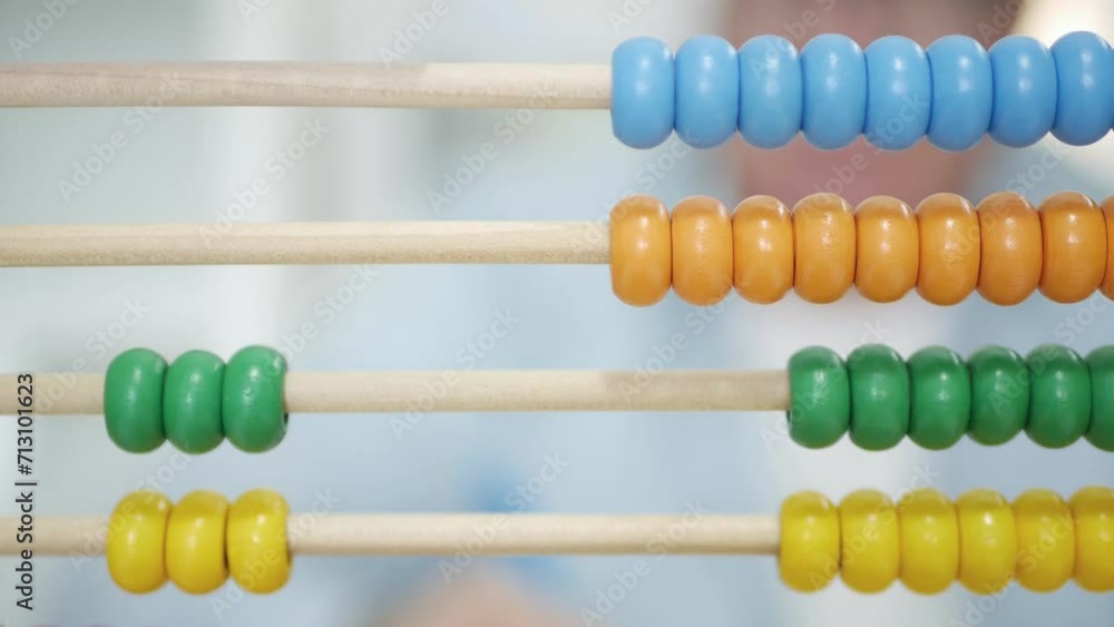 Blurred Shooting with a Man Using a Balls Calculator. A Counter with Colored Balls, a Tool Used by Kids for Learning to Calculate. Blurred Shooting with a Man Using a Balls Calculator. A Counter with Colored Balls, a Tool Used by Kids for Learning to Calculate.