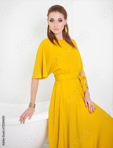 Beautiful girl with make up wearing long yellow dress photo