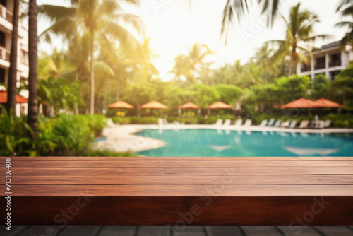 Wooden table pool bokeh background, empty wood desk product display mockup with blurry tropical hotel resort abstract poolside summer travel backdrop advertising presentation. Mock up, copy space. © Synthetica