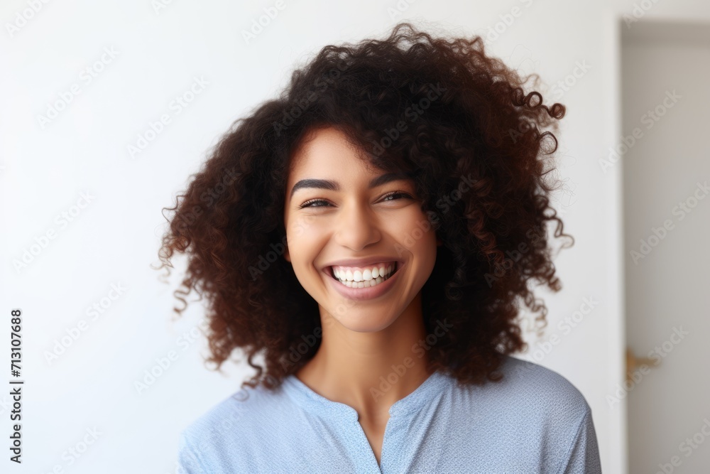 Portrait of beautiful young dark-skinned woman with shaggy hairstyle smiling showing white teeth Portrait of beautiful young dark-skinned woman with shaggy hairstyle smiling showing white teeth
