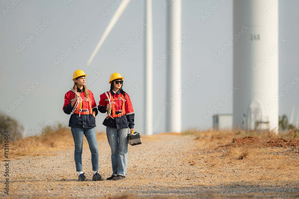 Both female engineers and wind turbines in a wind farm in the countryside of Thailand. Both female engineers and wind turbines in a wind farm in the countryside of Thailand.