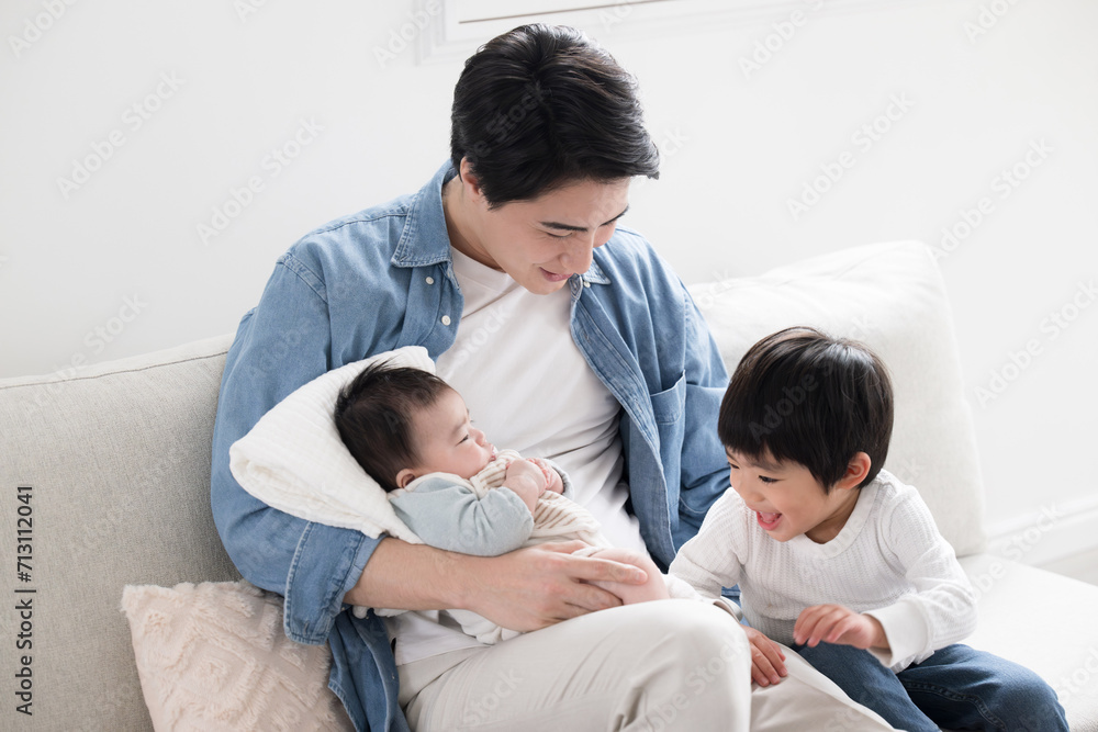 Fototapeta premium 赤ちゃんをあやしたりお世話をする優しいお兄ちゃん