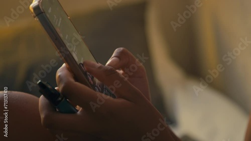 Closeup lowkey footage of pretty Black lady vaping at home while texting messages on mobile in eveningCloseup lowkey footage of pretty Black lady vaping at home while texting messages on mobile in eve photo