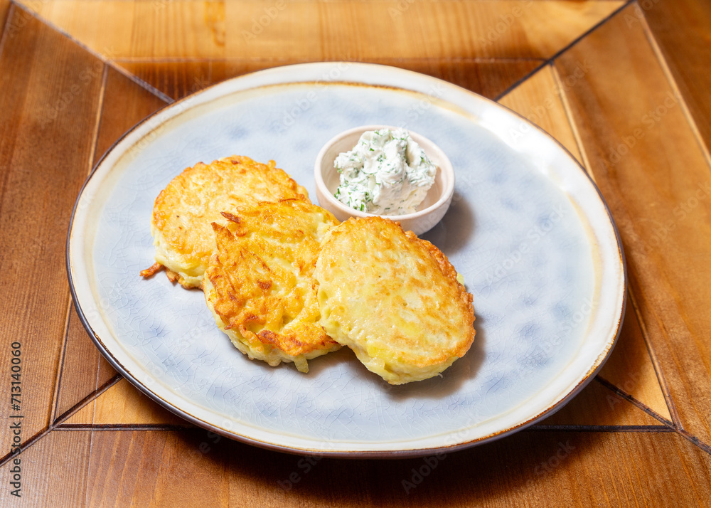 Potato pancakes with sour cream. On a wooden table. Potato pancakes with sour cream. On a wooden table.