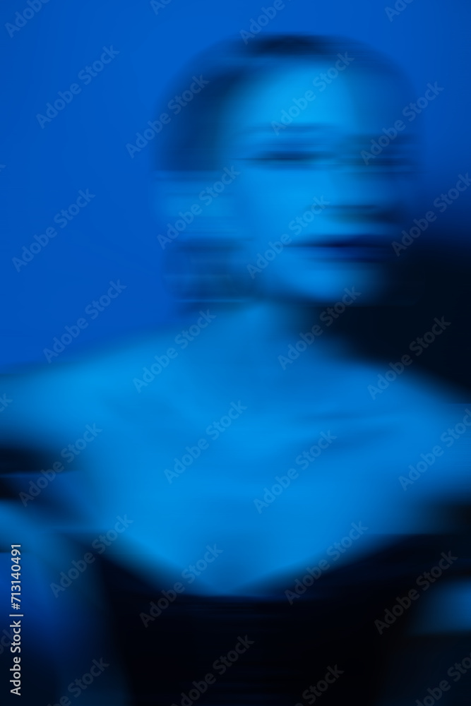 Beauty, fashion and make-up concept. Beautiful woman studio portrait with classic hairstyle, corset and round golden earrings. Toned image with vivid blue color. Motion blur effect style Beauty, fashion and make-up concept. Beautiful woman studio portrait with classic hairstyle, corset and round golden earrings. Toned image with vivid blue color. Motion blur effect style