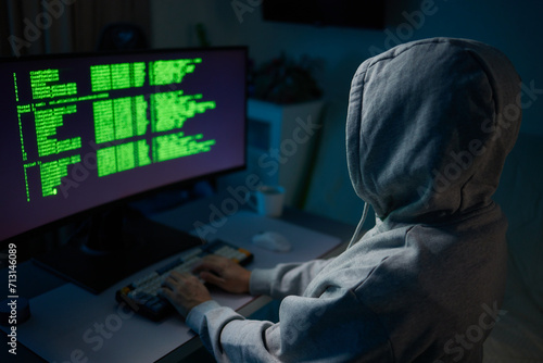 Hacker using the computer. Man in a hoodie breaks the access to steal information and infects computers and systems