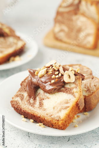 A piece of marble biscuit with chocolate cream and nuts