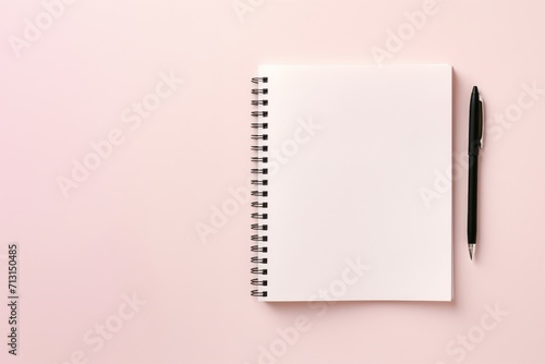 school notebook on a pink background, spiral notepad on a table photo