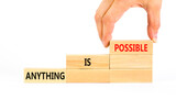 Anything is possible symbol. Concept words Anything is possible on beautiful wooden blocks. Beautiful white table white background. Businessman hand. Business anything possible concept. Copy space.