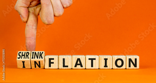 Inflation or shrinkflation symbol. Concept words Inflation Shrinkflation on beautiful wooden blocks. Beautiful orange background. Businessman hand. Business inflation shrinkflation concept. Copy space photo