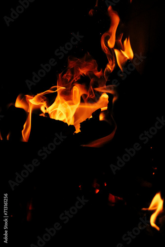 Fire in the fireplace black background. Red and yellow flame blaze, thermal energy during the night © Trik