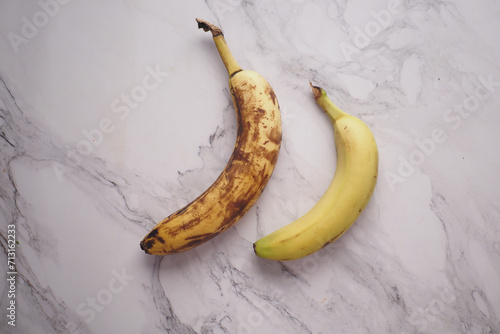 comparing rotten banana with a ripe banana on a white background