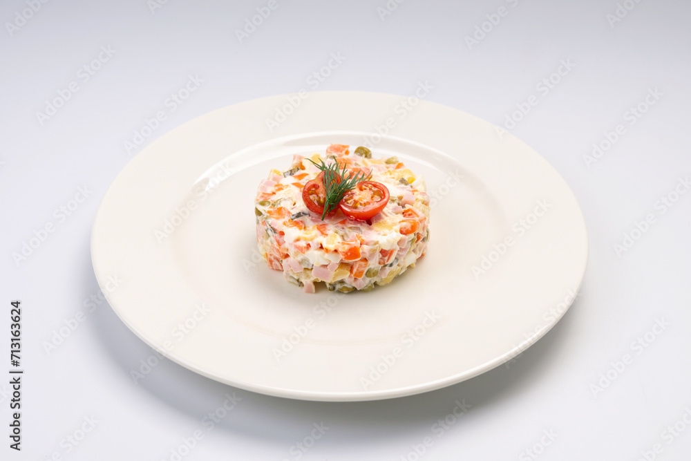 Breakfast. Traditional Russian salad on a white plate and a white background.