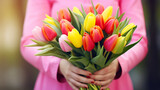 Close up of a woman hands holding vibrant bouquet colorful tulips