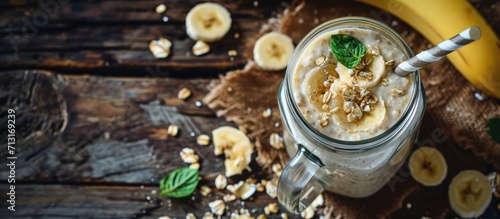 Banana oatmeal breakfast smoothie in mason jar on wood table downward view. Copy space image. Place for adding text