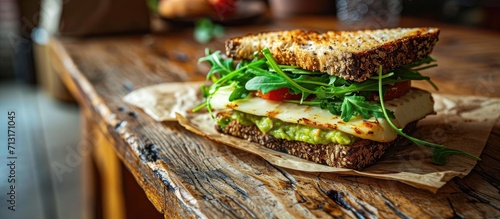 Grilled halloumi sandwich with avocado guacamole arugula Toast with grilled cheese and avocado Healthy food. Copy space image. Place for adding text photo